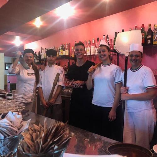a group of people standing in front of a bar at Ostello Trentapassi in Zone