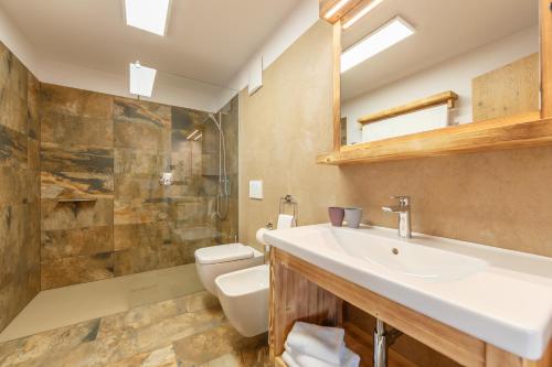 a bathroom with a sink and a toilet and a shower at Agriturismo MARER Urlaub auf dem Bauernhof in Villabassa