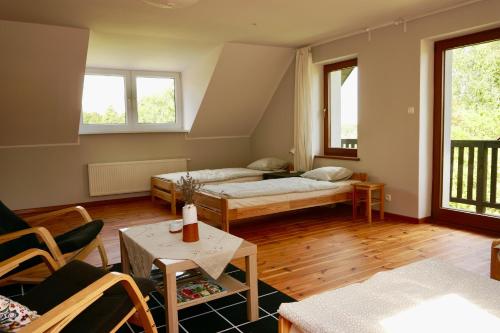 a living room with two beds and a table at Leśne zacisze in Rydzewo