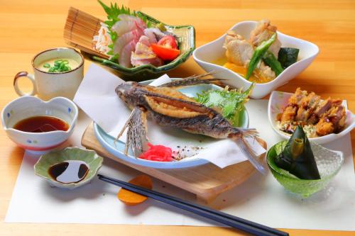 a plate of food with fish and other foods on a table at Tanegashima Minshuku Yuyu in Minamitane