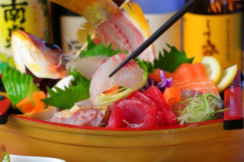 a bowl full of food with chopsticks in it at Tanegashima Minshuku Yuyu in Minamitane