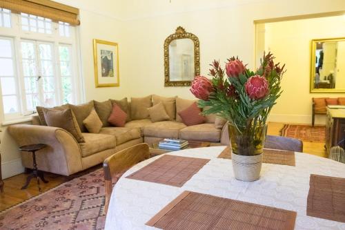 
a living room filled with furniture and flowers at 5 Camp Street Guesthouse & Self-catering in Cape Town
