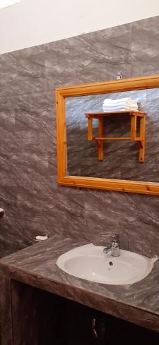 a bathroom sink with a mirror and a table at Sa House Bac Ha in Bắc Hà