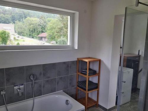 a bathroom with a bath tub and a window at Ferienwohnung Bella Casa in Öhningen