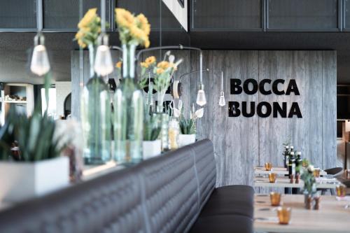 a restaurant with a bar with vases of flowers at Radisson Hotel Zurich Airport in Rümlang