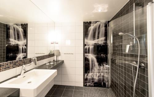 a black and white bathroom with a sink and a shower at Myrkdalen Resort Hotel in Myrkdalen 