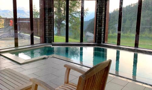 une piscine avec vue sur les montagnes dans l'établissement Arc 1950 Manoir Savoie Skis aux pieds, à Bourg-Saint-Maurice