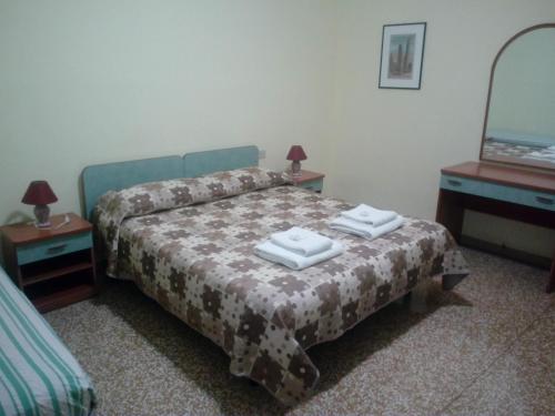 1 dormitorio con 1 cama con 2 toallas en B&B SILVANO, en Bolonia