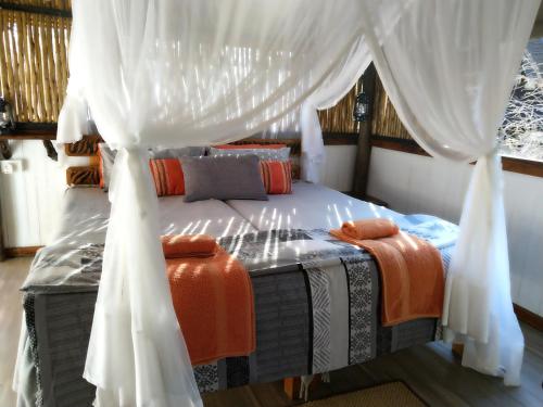 a bedroom with a bed with a canopy at Off Beat Safaris Bush Lodge in Hoedspruit