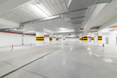 an empty parking garage with white floors and yellow and white columns at Apartament Jaskółcza 30 in Bydgoszcz