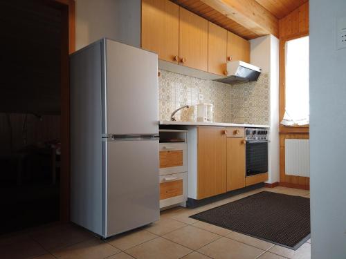 einen Kühlschrank aus Edelstahl in einer Küche mit Holzschränken in der Unterkunft Wenz Wohnung in Schwarzsee