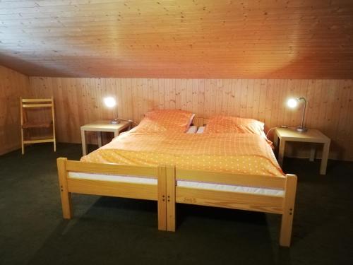 ein Schlafzimmer mit einem Bett mit zwei Tischen und zwei Lampen in der Unterkunft Wenz Wohnung in Schwarzsee