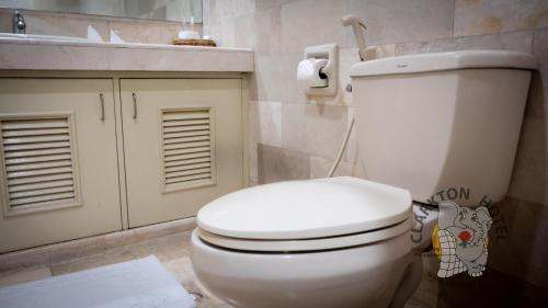 a bathroom with a white toilet and a sink at Clarkton Hotel Apartment in Angeles
