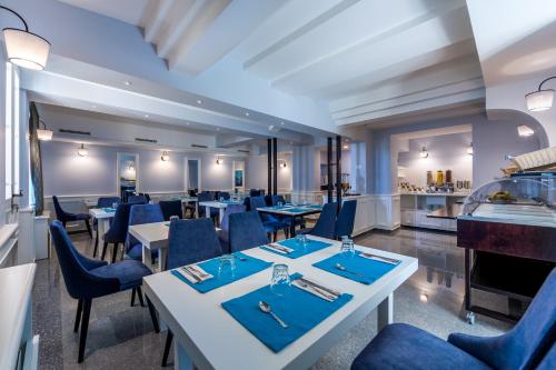 オパティヤにあるHotel Dominoのテーブルと椅子とバーのあるレストラン