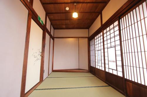 an empty room with windows and a corridor at Onomichi Guest House Miharashi-tei in Onomichi