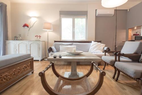 salon z kanapą i stolikiem kawowym w obiekcie Affordable luxury garden apartment w Atenach