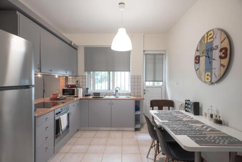 a kitchen with white cabinets and a table with chairs at Affordable luxury garden apartment in Athens