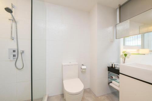 a white bathroom with a toilet and a sink at Dorsett Tsuen Wan, Hong Kong in Hong Kong