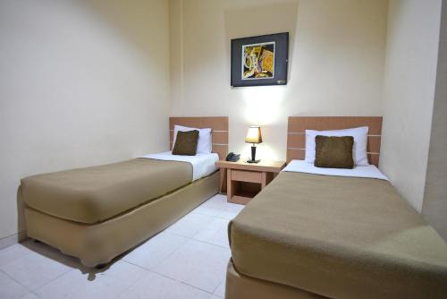 En eller flere senger på et rom på Hotel Graha DPT 33