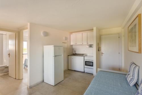 a kitchen with a white refrigerator and a stove at Oltremare Appartamenti in Principina a Mare