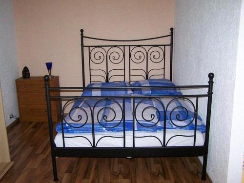 una camera da letto con letto nero e cuscini blu di Ferienwohnung Sandhaas a Ringsheim