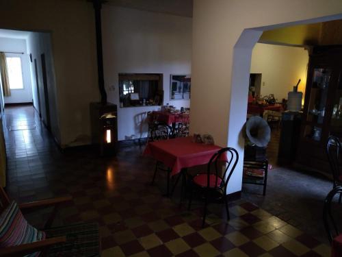 sala de estar con mesa roja y sillas en El Valle Hostería, en Mina Clavero