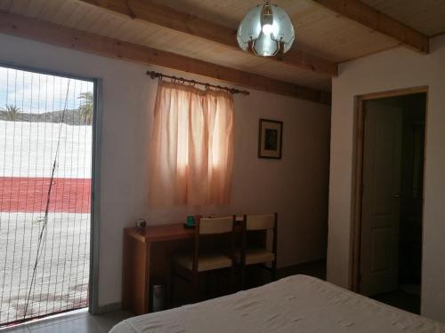 a bedroom with a bed and a desk and a window at Residencia Los Conejos - Bike & Motorbike in Las Palmas de Gran Canaria