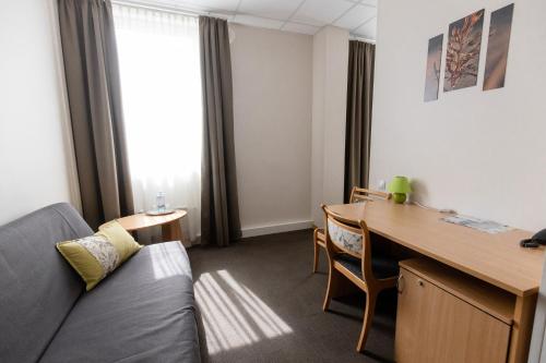 a living room with a couch and a desk at Sports Hotel in Valmiera