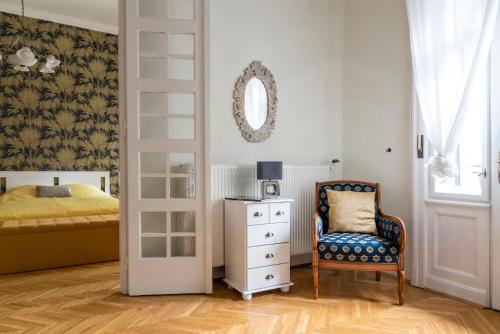 a bedroom with a bed and a chair and a mirror at Central Apartman in Budapest