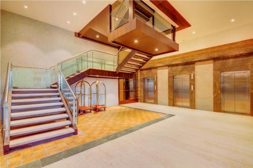 a lobby with a staircase and a glass stair case at The Fern An Ecotel Hotel, Lonavala in Lonavala