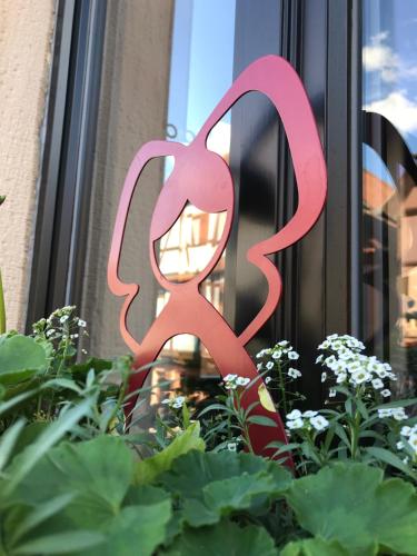 a pink metal sculpture in a garden at La bacchante in Saint-Hippolyte