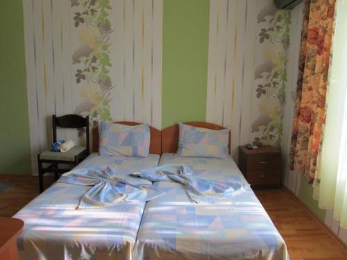 a bed with blue and white sheets and bows on it at Стаи за гости ЖАНА in Varna City