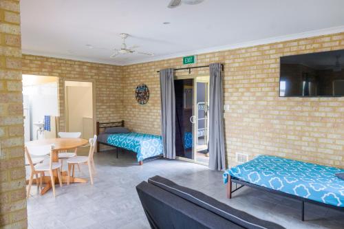 a room with two beds and a table and a dining room at Lancelin Lodge in Lancelin