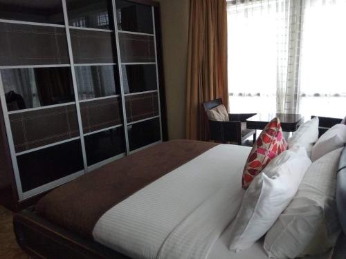 a bedroom with a large bed with white sheets and pillows at Times Square Private Service Suite At KL in Kuala Lumpur