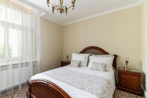 a bedroom with a large bed and a chandelier at Baltic Beach Hotel & SPA in Jūrmala