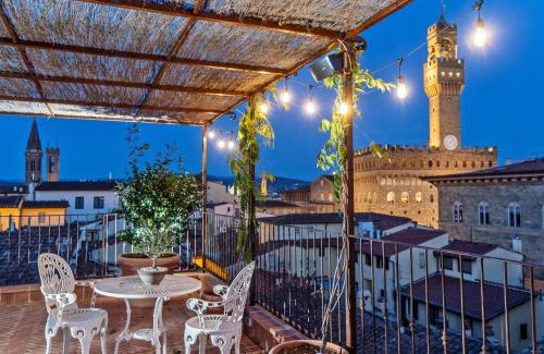 an outdoor dining area with tables, chairs and umbrellas at Hotel Calimala in Florence
