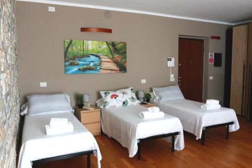 Zimmer mit 2 Betten und Wandgemälde in der Unterkunft Bnbook - Metropolitan Expo Flat in Rho