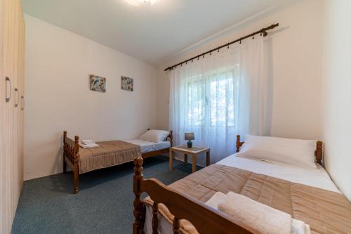 a bedroom with two beds and a window at House Gorica in Bar