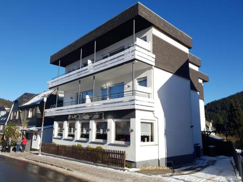 a white building with a black roof at Sevda's Hotel Garni Weinforth in Willingen