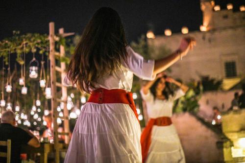 a woman in a white dress standing in front of a building at Borgo Egnazia in Savelletri di Fasano