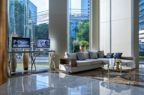 a living room with a couch and a table at Ashley Wahid Hasyim Jakarta in Jakarta