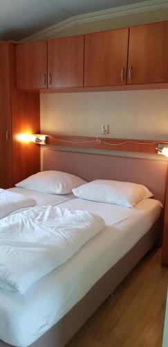 2 bedden met witte lakens en kussens in een kamer bij De Zeeuwse Lûûkjes 2 in Baarland