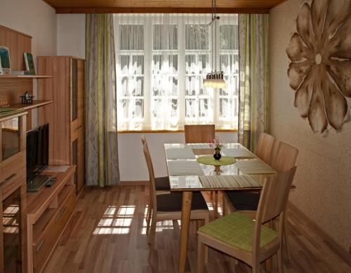 a dining room with a table and chairs and a window at Ferienwohnung Villa Heinrich in Feld am See