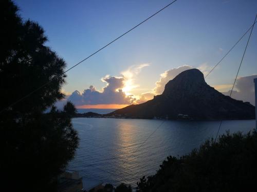 a sunset over a body of water with a mountain at Afroditi Hotel in Masouri