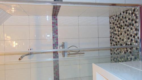 een badkamer met een douche en een glazen deur bij chez MARIA in Coucy-le-Château-Auffrique