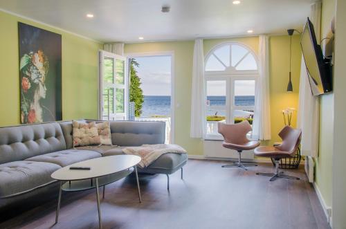 a living room with a couch and a table and chairs at Østersø kystlejligheder in Nysted
