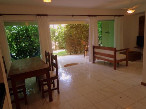 a dining room with a table and a bench at Apartamentos Breezes com verde, sossego e preço justo - ideal para famílias e amigos em Imbassaí in Imbassai