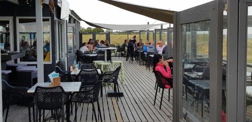 a group of people sitting at tables on a deck at De Zeeuwse Lûûkjes 2 chalet 703 in Baarland