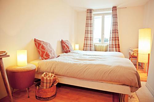une chambre avec un lit, une table et une fenêtre dans l'établissement L'Atelier Du Peintre, à Ornans
