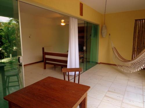 a room with a hammock and a table and chair at Apartamentos Breezes com verde, sossego e preço justo - ideal para famílias e amigos em Imbassaí in Imbassai